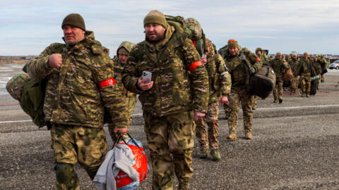 Volunteers, who joined the Russian armed forces and took military training in Chechnya, board a plane before departing for positions of the Akhmat battalion involved in Russia's military campaign in 