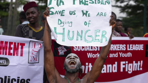 Mwandamanaji anaonyesha bango lililoandikwa: "Bw. rais, tuokoe, tunakufa njaa." Lagos, Jumatatu Agosti 5, 2024.