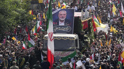 Iranians follow a truck, center, carrying the coffins of Hamas leader Ismail Haniyeh and his bodyguard who were killed in an assassination blamed on Israel on Wednesday, during their funeral ceremony at Enqelab-e-Eslami (Islamic Revolution) Sq. in Tehran, Iran, Thursday, Aug. 1, 2024. 