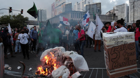 Manifestantes queman basura tras derribar las vallas que protegían la Asamblea Nacional durante una protesta para exigir al gobierno medidas para frenar la inflación, bajar los precios de los combustibles y de los alimentos, en Ciudad de Panamá, el 12 de julio de 2022.