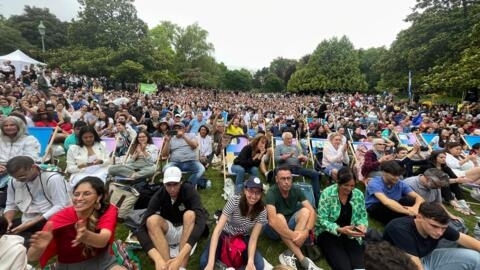Parisienses e turistas no Parc Monceau, em Paris, onde assistiram a cerimônia de abertura num telão.