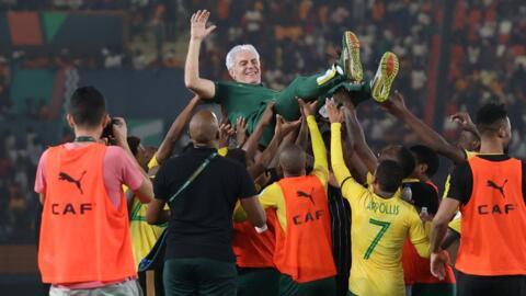 South Africa players celebrate with head coach Hugo Broos after beating Democratic Republic of Congo in a penalty shoot-out to claim third place at the 2023 Africa Cup of Nations.