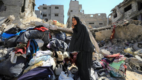 Mulher tenta levar pertences em meio à ofensiva israelense em Shejaiya, em Gaza. (10/07/2024)