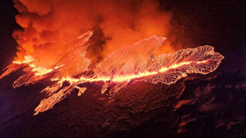 2023 年 12 月 18 日，冰岛格林达维克，一座火山在喷发时喷出熔岩和浓烟。