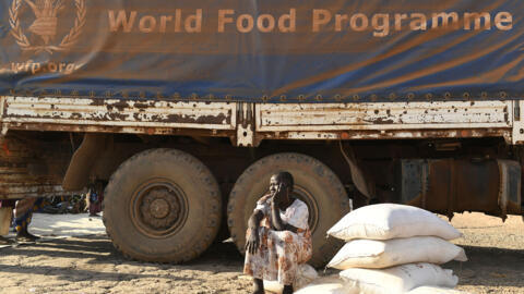 Uma mulher vítima de deslocamento forçado se senta ao lado de um caminhão do Programa Mundial de Alimentos, na cidade de Bentiu, no Sudão do Sul, considerado o país mais perigoso para trabalhadores humanitários. Em 6 de fevereiro de 2023.