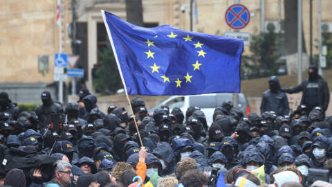 Манифестант держит флаг Европейского союза во время акции протеста против законопроекта об «иностранных агентах» в Тбилиси, 14 мая 2024 года.