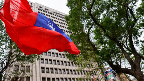 A supporter of the main opposition party Kuomintang (KMT) waves a Taiwanese flag outside of the Central Election Commission in Taipei, Taiwan November 24, 2023. REUTERS/Ann Wang