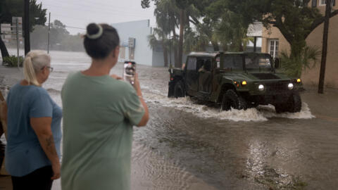 Um veículo da Guarda Nacional na Flórida atravessa uma rua inundada, após a passagem do furacão Debby em 5 de agosto de 2024, em Cedar Key, Flórida, Estados Unidos. 