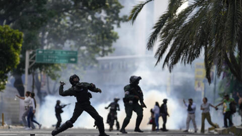 A polícia atira um projétil de gás contra manifestantes que protestam contra os resultados oficiais das eleições que declaram a reeleição do presidente Nicolas Maduro, no dia seguinte à votação em Caracas, Venezuela, na segunda-feira, 29 de julho de 2024.