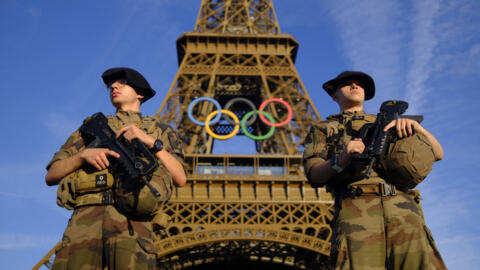 Soldiers patrol on a street in front of the Eiffel Tower ahead of the Paris Olympics, 21 July, 2024