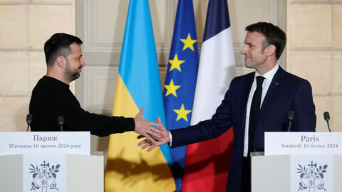 Le président français Emmanuel Macron (à droite) serre la main à son homologue ukrainien Volodymyr Zelensky (à gauche) après la signature d'un accord de sécurité, le 16 février 2024, à Paris.