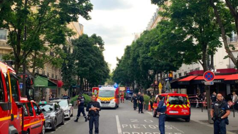 Des policiers français se tiennent à côté de véhicules de secours, près du café Le Ramus, à Paris, le 17 juillet 2024