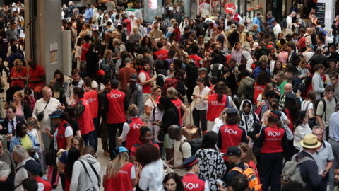 Des employés de la SNCF s'adressent aux passagers attendant le départ de leur train à la gare Montparnasse, alors que le réseau ferroviaire à grande vitesse français a été touché par des actes malveillants. Paris le 26 juillet 2024.