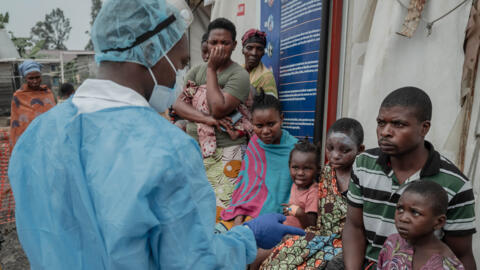 Patients listen to a doctor outside the consultation room of the Mpox treatment centre at Nyiragongo General Referral Hospital, north of Goma, in the DRC, on 17 August, 2024.