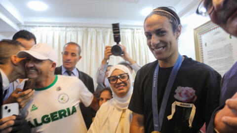 Algerian gold medallist Imane Khelif poses for a picture as she sits with relatives in her hometown city of Tiaret on 16 August 2024.