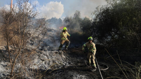 Bombeiros apagam chamas no local do ataque com mísseis houthis na região de Lod, no centro de Israel, em 15 de setembro de 2024.