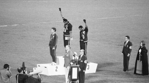 Los medallistas de oro y bronce de EE.UU. Tommie Smith (centro) y John Carlos (derecha) levantan el puño como gesto contra el racismo en el podio olímpico, el 16 de octubre de 1968.