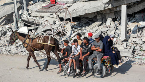 Des habitants se déplacent au milieu des décombres d'un bâtiment effondré à Khan Yunis, dans le sud de la bande de Gaza, le 4 septembre 2024.