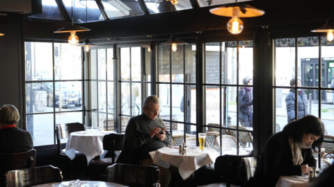 A customer sits in a restaurant, in Paris, Monday, Jan. 24, 2022.