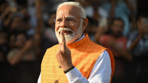 El primer ministro Narendra Modi muestra su dedo manchado de tinta tras votar en Ahmedabad, el 7 de mayo de 2024 al oeste de India