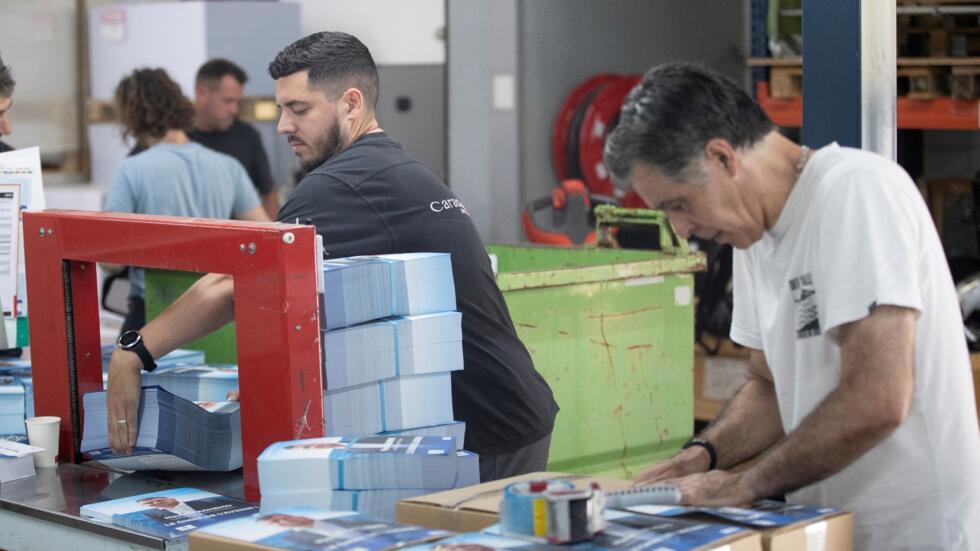 Workers at a printing company in Marseille pack up campaign materials for the upcoming parliamentary elections in France, on 18 June 2024.