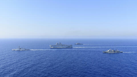 In this photo provided by the Greek National Defence, a French Tonnerre helicopter carrier, center, and French Lafayette frigate, left, are escorted by Greek and French military vessels during a marit