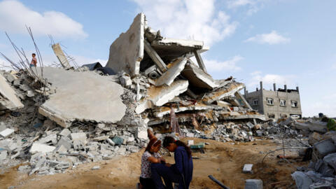 Palestinian children sit next to the site of an Israeli strike on a house, amid the ongoing conflict between Israel and the Palestinian Islamist group Hamas, in Rafah, in the southern Gaza Strip, Apr