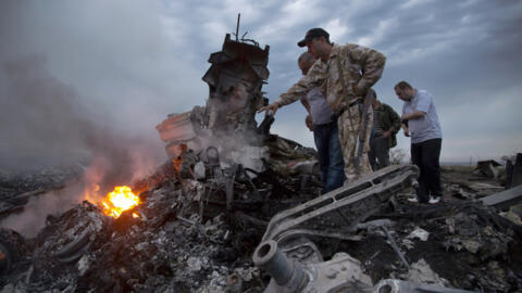 People inspect the crash site of a passenger plane near the village of Hrabove, Russian-controlled Donetsk region of Ukraine on Thursday, July 17, 2014.