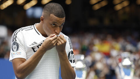 Kylian Mbappé besa el escudo del Real Madrid durante su presentación como nuevo jugador del club español (16/07/2024)