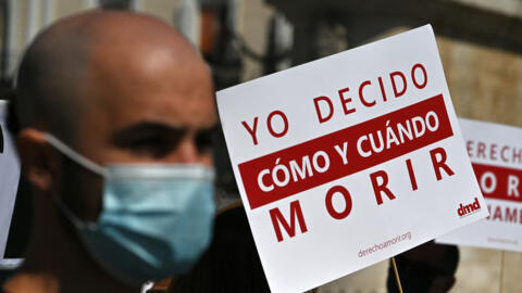 Miembros del grupo 'Derecho a una Muerte Digna' asisten a una manifestación para apoyar la nueva Ley de Eutanasia española en la Plaza Puerta del Sol de Madrid. (Foto de Gabriel BOUYS / AFP)