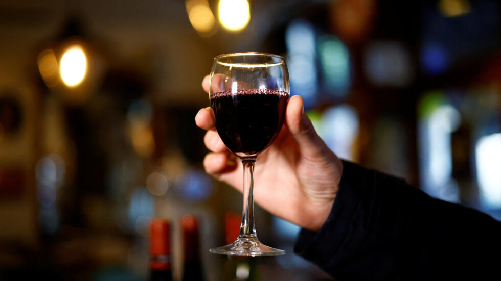 A customer holds a glass of Beaujolais Nouveau wine at Le Mesturet restaurant in Paris, France, November 16, 2023.