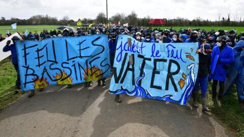 Protesters hold a banner as they head to Sainte-Soline during a demonstration called by the collective "Bassines non merci", the environmental movement "Les Soulevements de la Terre" and the French trade union 'Confederation paysanne' to protest against the construction of a new water reserve for agricultural irrigation, between Vanzay and Sainte-Soline, central-western France, on 25 March, 2023.