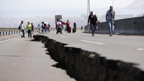 La gente camina junto a una grieta a lo largo de un camino dañado que conduce a la comuna de Alto Hospicio, después de una serie de réplicas, en el puerto norteño de Iquique el 3 de abril de 2014. Un fuerte terremoto de magnitud 7,6 sacudió el norte de Chile en la víspera, pero no hubo informes de daños y se canceló una alerta de tsunami de precaución a lo largo de la costa y en el vecino Perú. REUTERS/Ivan Alvarado 