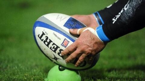 Un ballon de rugby positionné sur un tee, lors d'un match de Top 14.