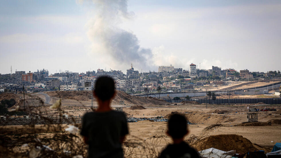 Des enfants regardent la fumée s'échapper lors des frappes israéliennes à l'est de Rafah, dans le sud de la bande de Gaza, ce lundi 13 mai 2024.