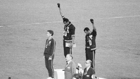 Tommie Smith (c) et John Carlos (d) les poings levés en soutien à la cause des Afro-Américains sur le podium du 200 mètres aux JO de Mexico en 1968, avec l'australien Peter Norman (g).