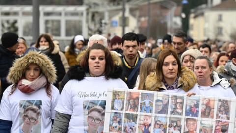 Severine (2ndL), the mother of 13-year old Lucas, and relatives pay homage to the teenager after he took his own life in January 2023. 