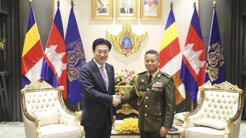 In this photo released by Cambodian Defense Ministry, Japanese Defense Minister Minoru Kihara, left, shakes with his Cambodian counterpart Tea Seiha at the Defense Ministry in Phnom Penh, Cambodia, Mo