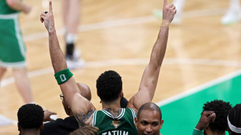 Jayson Tatum des Boston Celtics lève les bras pendant les dernières secondes du quatrième quart-temps du match 5 de la finale NBA 2024 contre les Dallas Mavericks au TD Garden à Boston, le 17 juin 2024