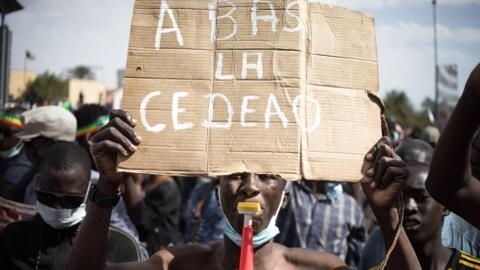 A demonstrator in Bamako, Mali, holds a sign reading "Down with Ecowas" during a demonstration in January to protest against sanctions imposed on Mali and its junta by the regional group. 