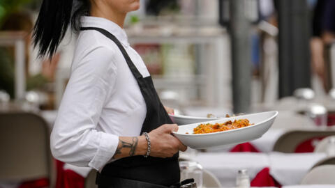 A waitress serves pasta in a restaurant in Milan, northern Italy, Thursday, June 8, 2023.