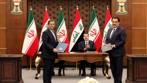 Iranian President Masoud Pezeshkian and Iraqi Prime Minister Mohammed Shia al-Sudani react as Chairman of the Baghdad Chamber of Commerce, Firas Rasool exchanges a Memorandum of Understanding with the