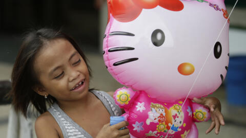 In this Friday, Oct. 17, 2014 photo, a girl admires a Hello Kitty balloon sold in Manila, Philippines.