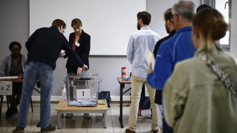 Candidatos fazem fila para votar no segundo turno das eleições legislativas antecipadas na França, neste domingo, 7 de julho de 2024.