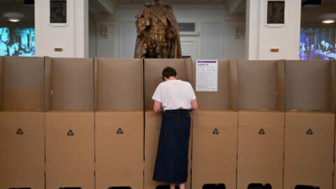 Uma mulher vota durante o pleito antecipado para o referendo de "A Voz" Indígena ao Parlamento, no Museu da Democracia Australiana, no antigo Parlamento, em Canberra, Austrália, em 3 de outubro de 2023.