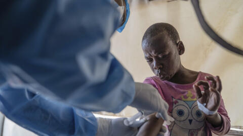 A health worker attends to a mpox patient at a treatment centre in Munigi, eastern Congo, on 19 August 2024. 