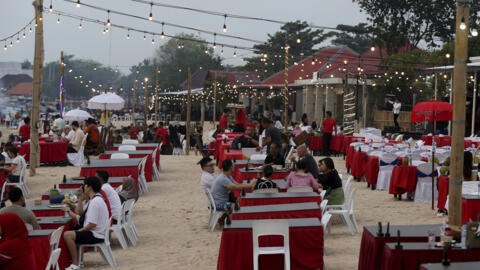 Tourists sit at a restaurant on Jimbaran Beach in Bali, Indonesia on Saturday, Nov. 12, 2022.