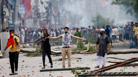 A demonstrator gestures as protesters clash with Border Guard Bangladesh (BGB) and the police outside the state-owned Bangladesh Television as violence erupts across the country after anti-quota protests by students, in Dhaka, Bangladesh, July 19, 2024. 