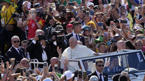 Young people cheer as Pope Francis arrives at the welcoming ceremony of the 2023 World Youth Day in Portugal on 3 August.