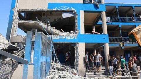 Palestinos observan los daños causados por los ataques israelíes contra la escuela gestionada por la UNRWA en el campo de refugiados de Nuseirat, en la Franja de Gaza, el 14 de julio de 2024.